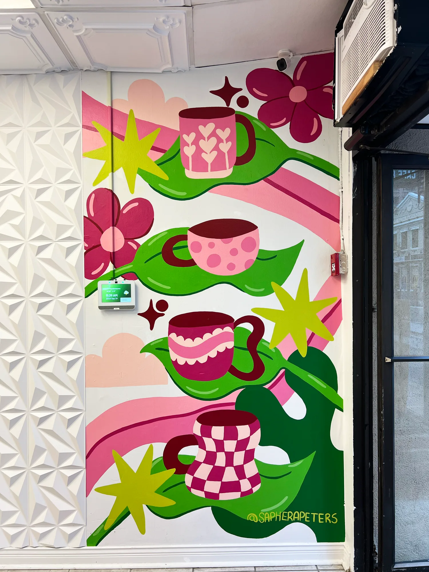 Detail of the Cafe Nitro mural showing a checkered pink coffee cup, a pouring drip and bold flowers
