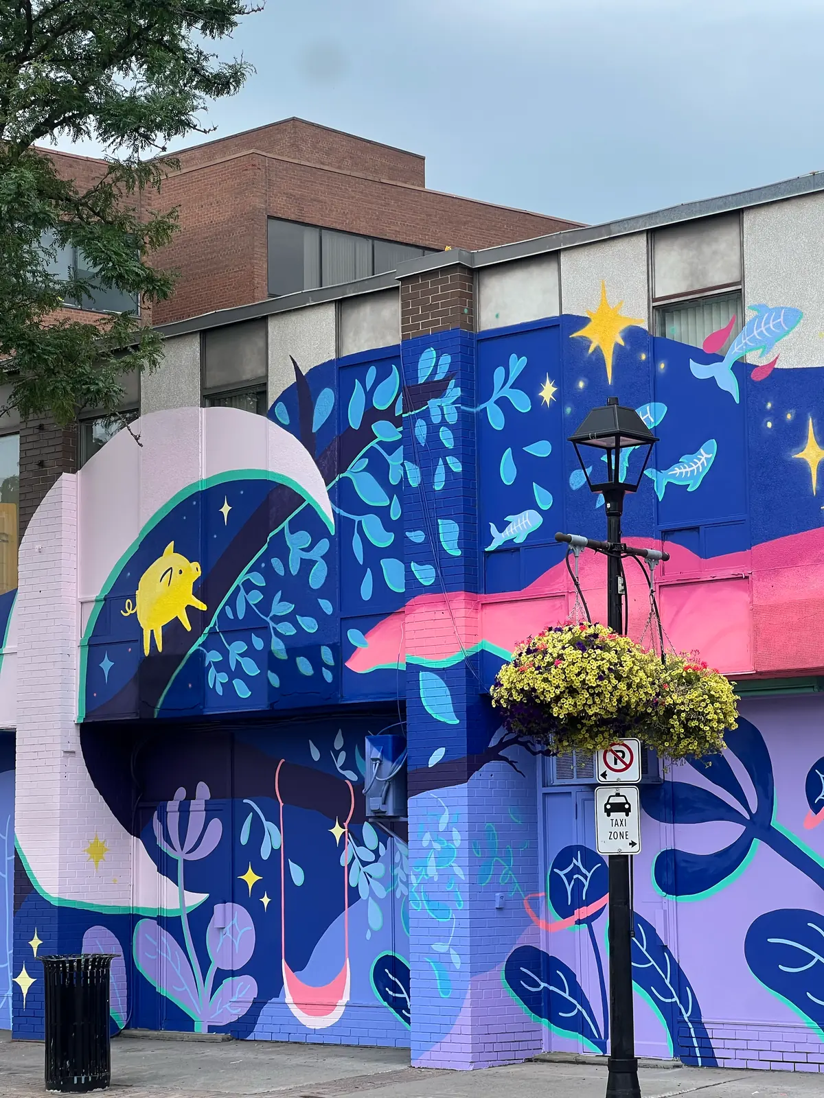 Section of the mural showing a crescent moon, stars and blue foliage against a deep blue ground