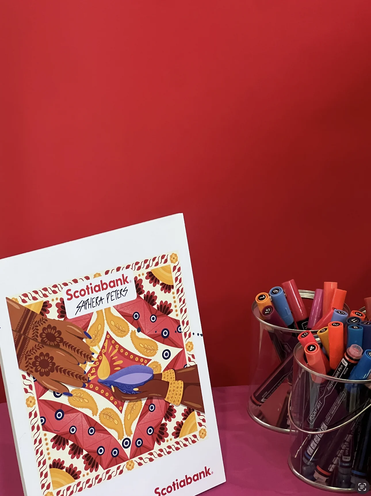 The full-colour reference print of the illustration displayed beside pots of markers