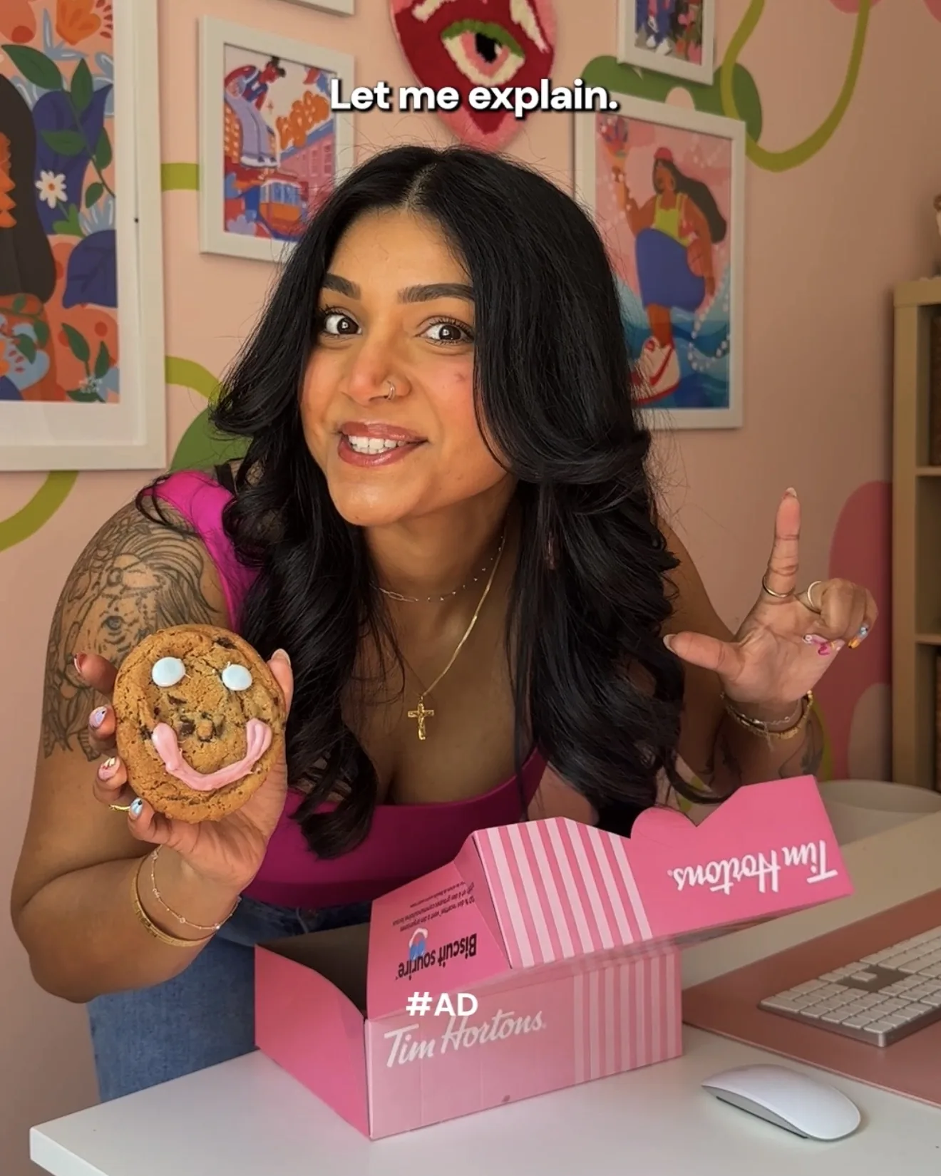 Saphera holding a Smile Cookie beside an open Tim Hortons Smile Cookie box