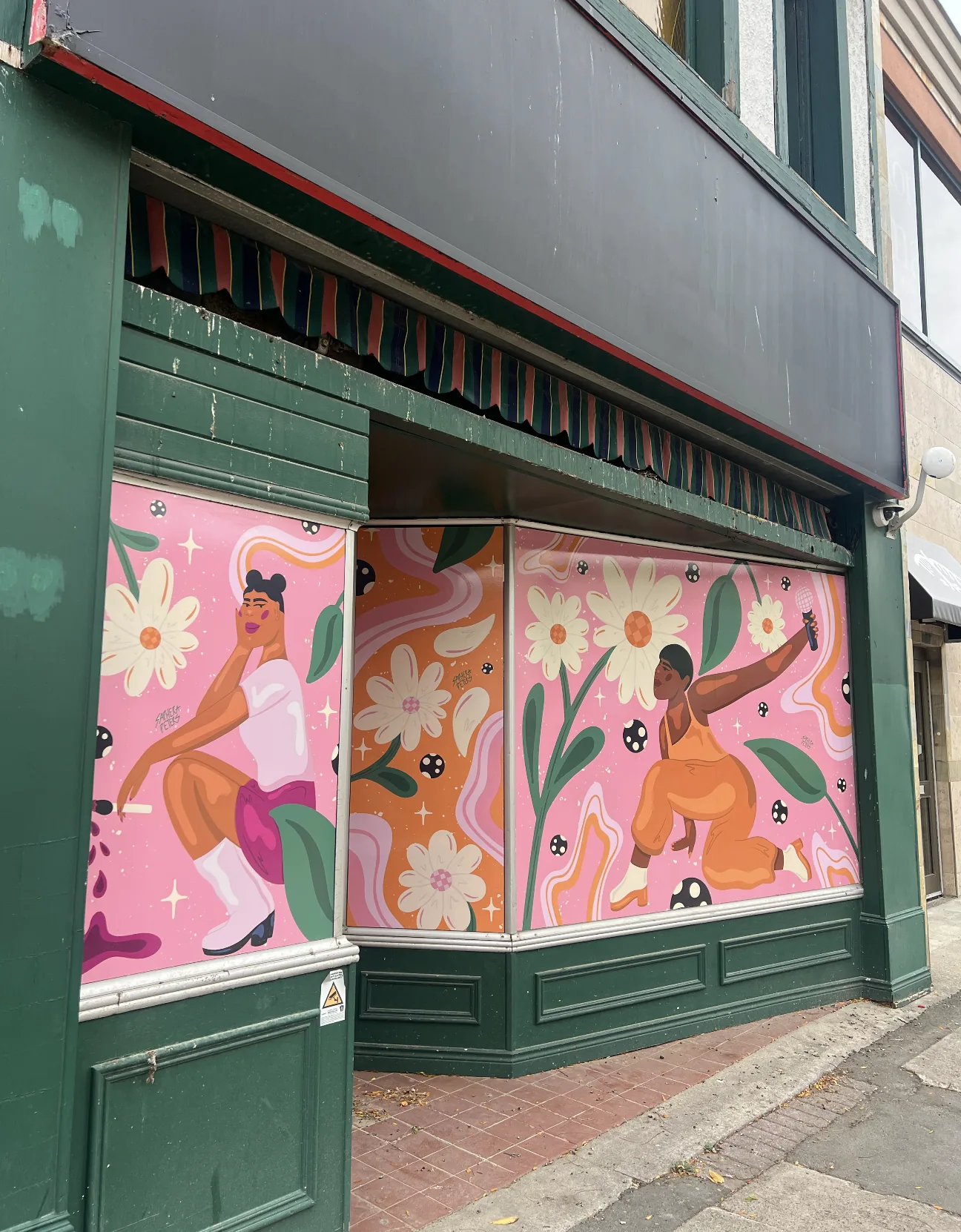 Storefront vinyl mural in pinks and creams showing figures at the farmers market