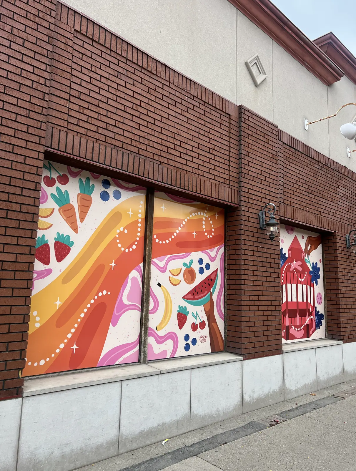 Vinyl mural panel featuring Brampton monuments including City Hall in warm oranges and pinks